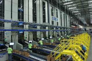 ASRS System with multiple workers in lime green t shirts and yellow railing