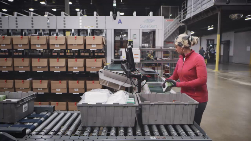 suresort-case-to-aisle Woman in head scarf and red fleece using OPEX sure sort
