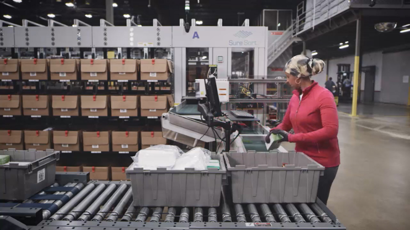 Woman in head scarf and red fleece using OPEX sure sort